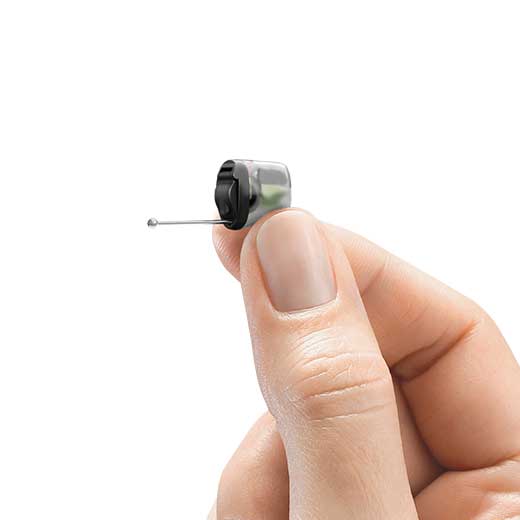 Invisible hearing aid in hand